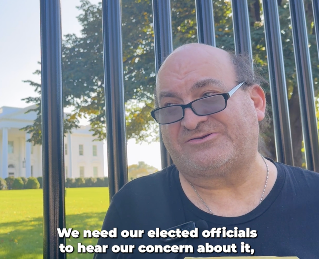 Man with glasses in front of the white house
